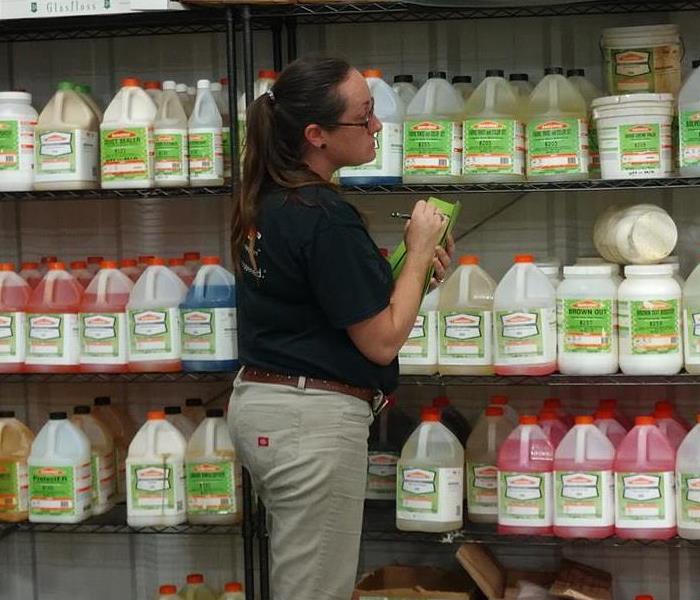 SERVPRO Employee  taking inventory of the cleaning solutions in the warehouse